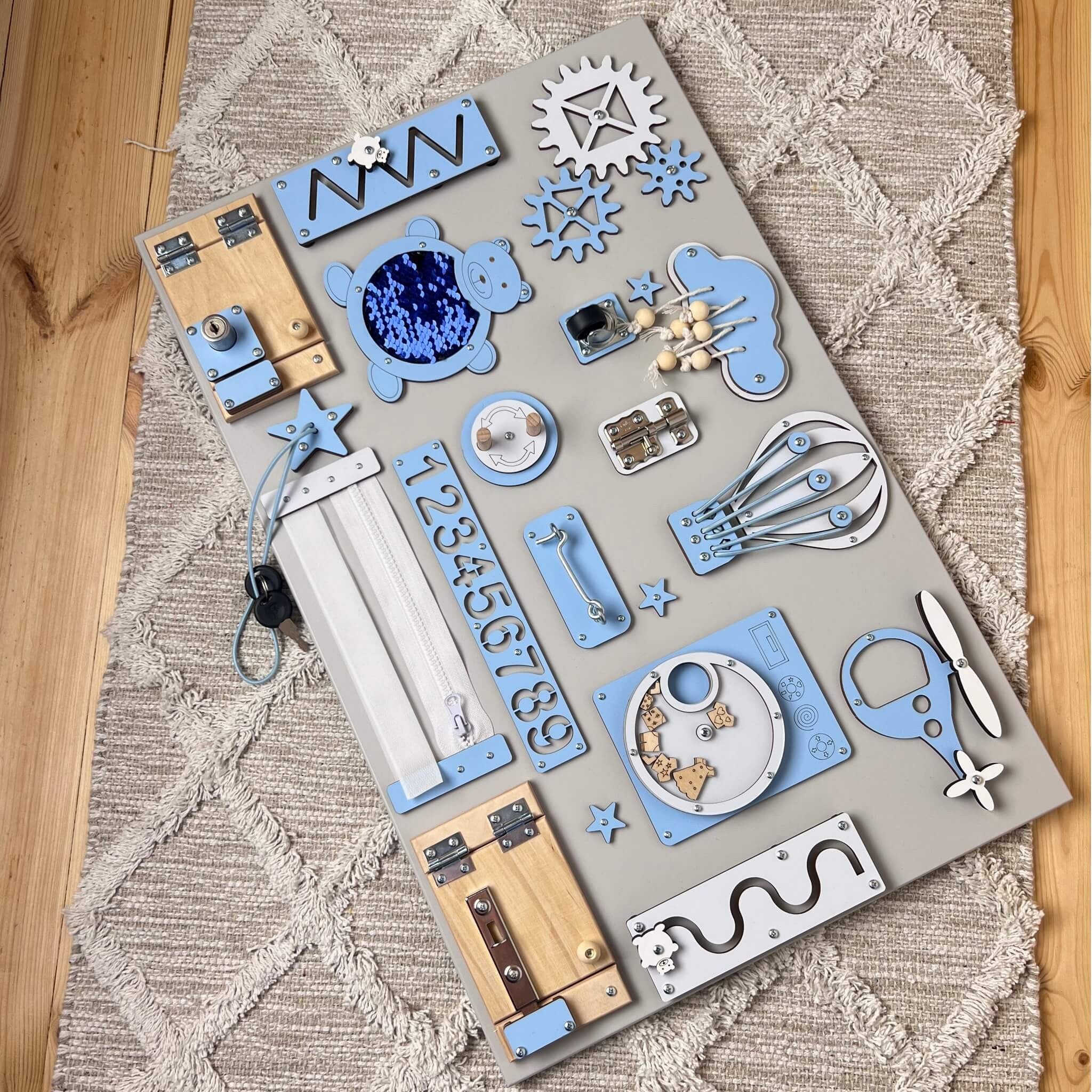 Montessori busy board avec portes et interrupteurs (40×60 cm)